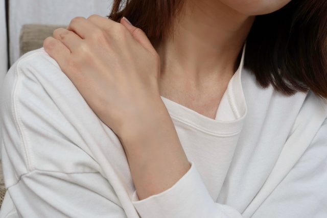肩こりで辛そうな女性